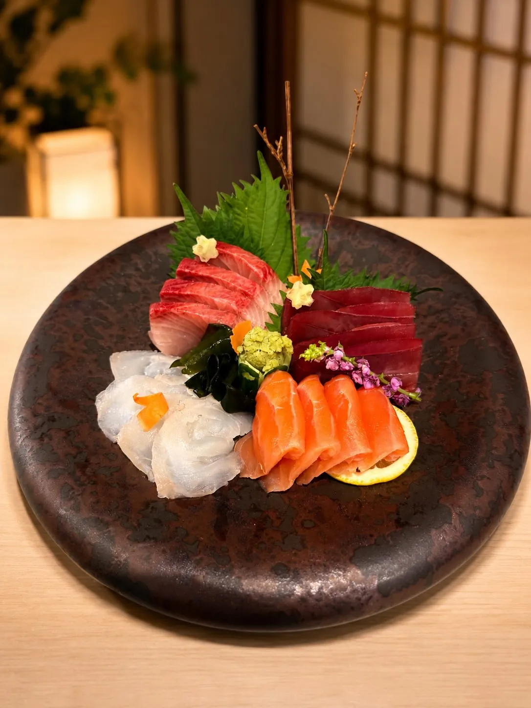 Apresentação de sashimi criada por William Utida, com cortes de pescados e elementos florais